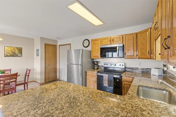 a kitchen with stainless steel appliances granite countertop a sink stove and refrigerator