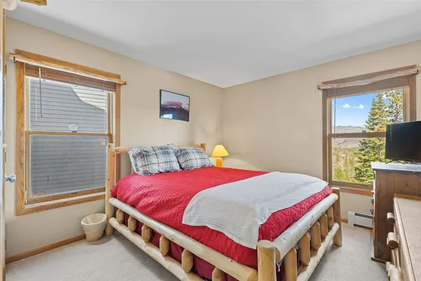 a bedroom with a bed and a flat tv screen next to a window