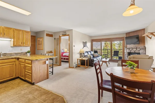 a kitchen with sink refrigerator dining table and chairs