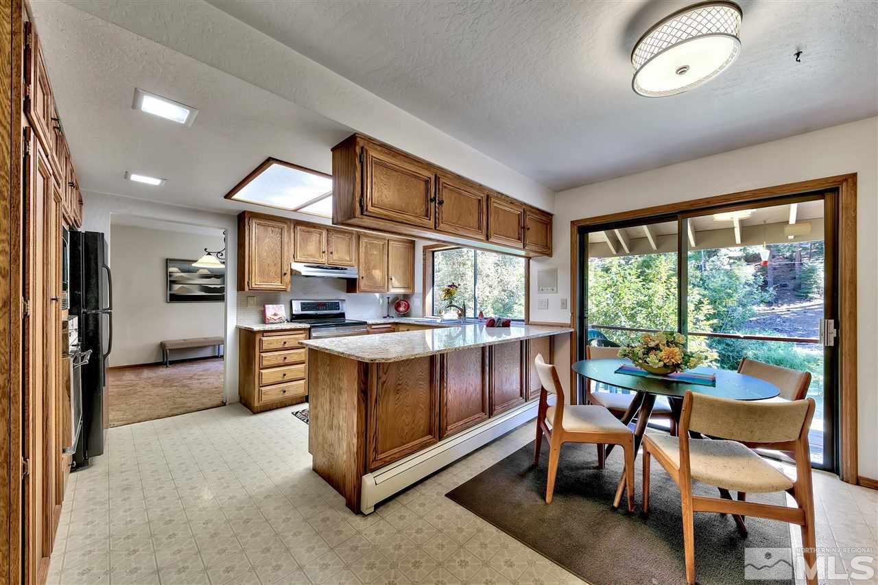 361 Summit Drive Stateline, NV 89449 - Photo 16 of 35 a kitchen with stainless steel appliances granite countertop a stove a refrigerator a kitchen island a table and chairs in it