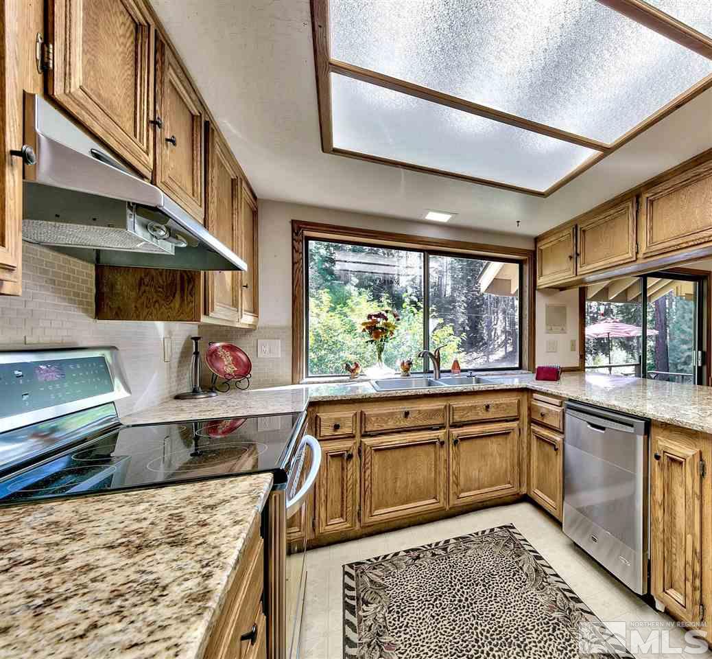 361 Summit Drive Stateline, NV 89449 - Photo 21 of 35 a kitchen with stainless steel appliances granite countertop a sink and wooden cabinets