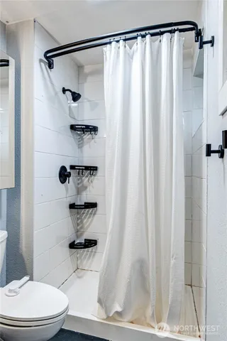 a bathroom with a shower curtain and a toilet