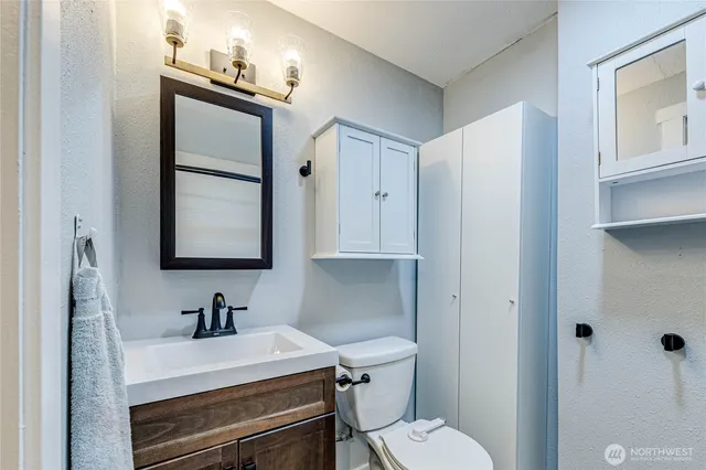 a bathroom with a sink vanity mirror and toilet