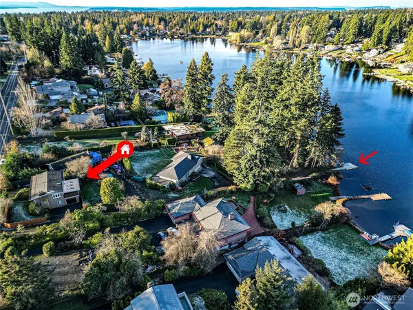 an aerial view of residential houses with outdoor space and lake view