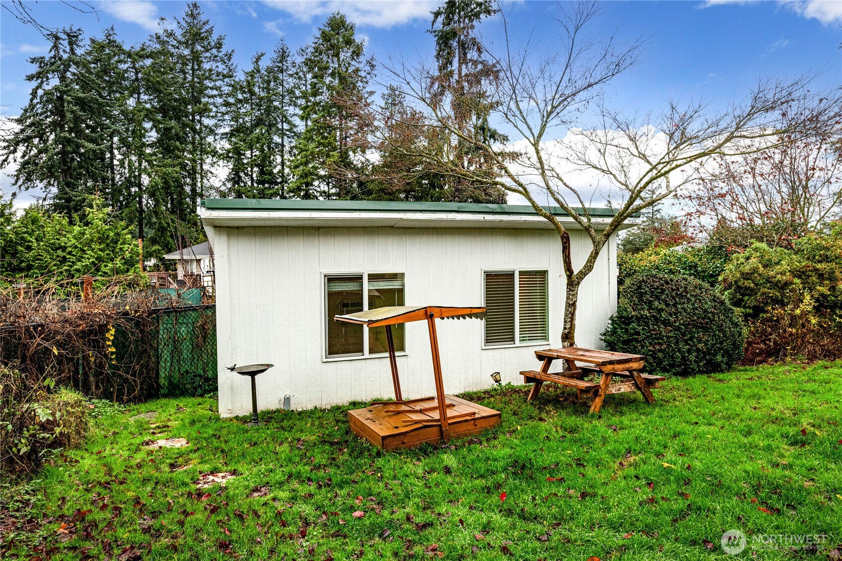 3623 Shelby Road Lynnwood, WA 98087 - Photo 30 of 39 a view of a backyard with table and chairs a barbeque and a large trees