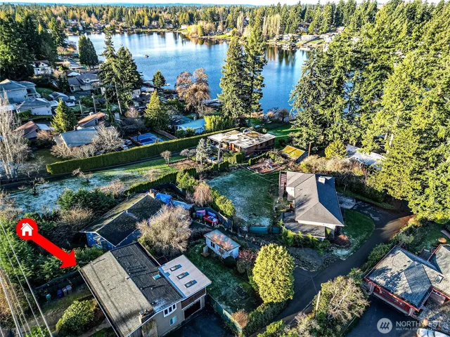 an aerial view of lake and residential houses with outdoor space