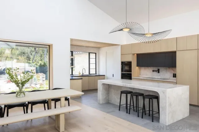 a kitchen with a table chairs refrigerator and microwave