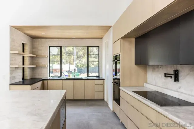 a kitchen with a sink a counter top space and stainless steel appliances