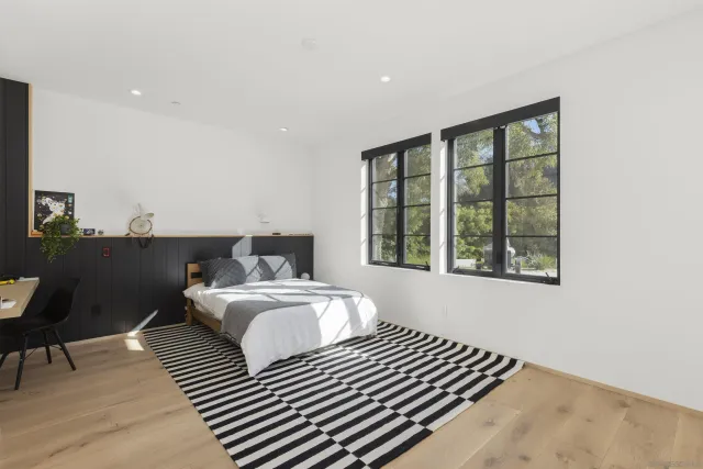 a bedroom with a bed and wooden floor