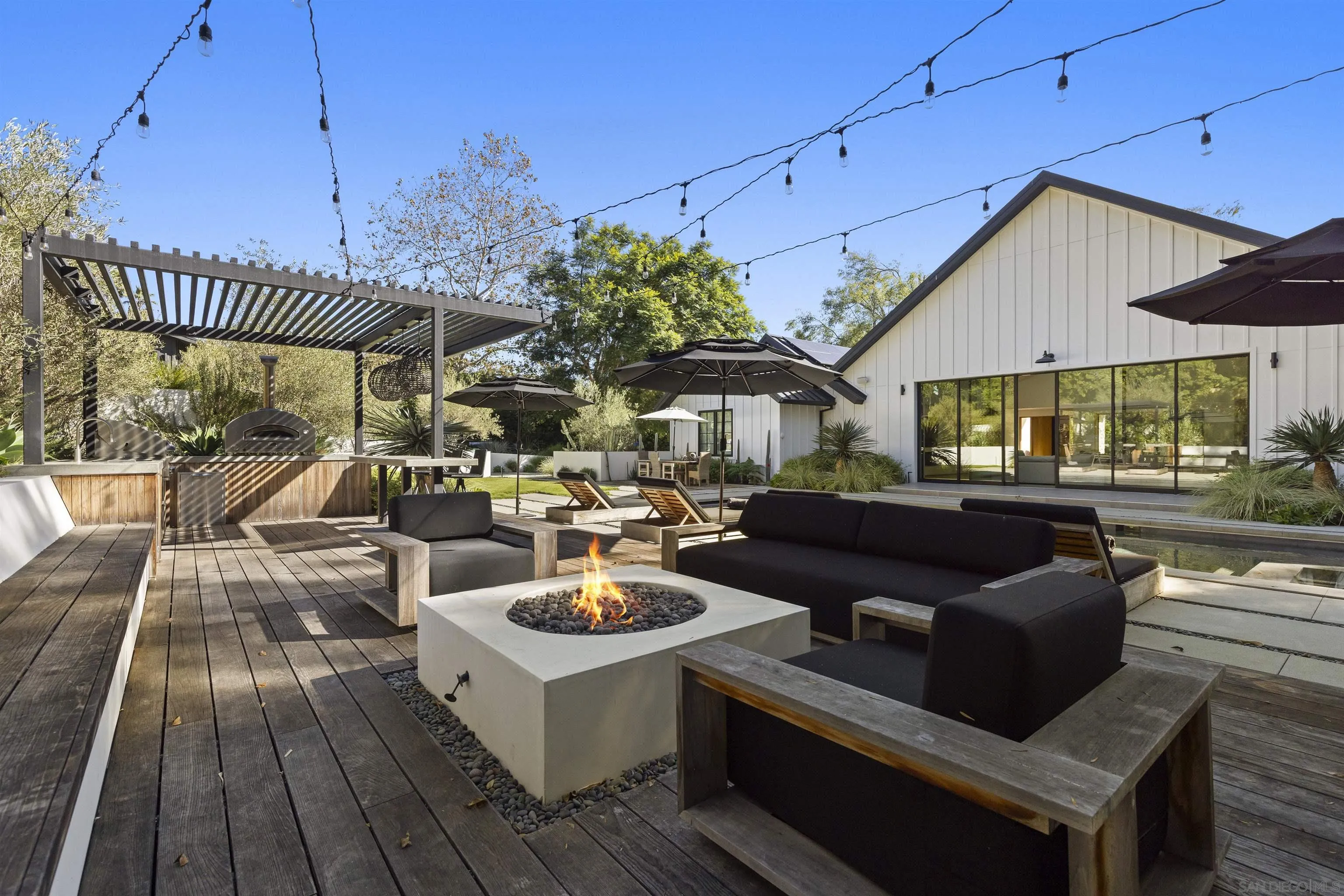 4874 Sun Valley Road Del Mar, CA 92014 - Photo 32 of 42 a view of a patio with couches and a table and chairs with wooden floor