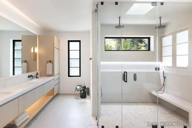 a spacious bathroom with a double vanity sink a mirror and a bathtub