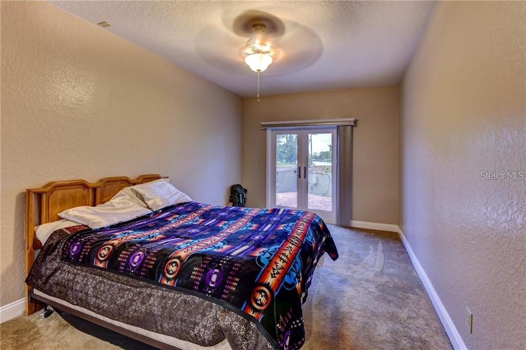 910 North Kepler Road DeLand, FL 32724 - Photo 38 of 52 a bedroom with a bed and a chandelier