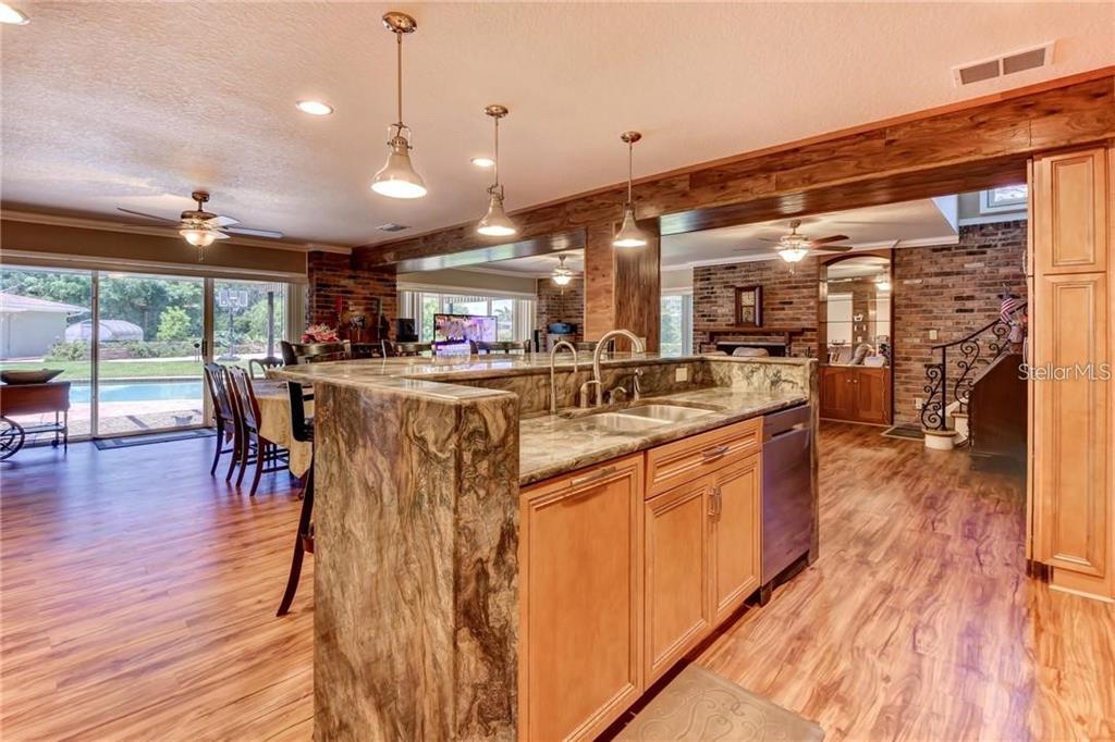 910 North Kepler Road DeLand, FL 32724 - Photo 8 of 52 a kitchen with stainless steel appliances granite countertop table chairs stove and wooden floor