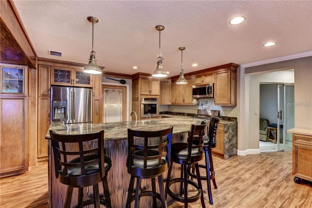910 North Kepler Road DeLand, FL 32724 - Photo 10 of 52 a kitchen with stainless steel appliances kitchen island granite countertop a dining table chairs and wooden floor
