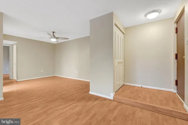 a view of empty room with wooden floor