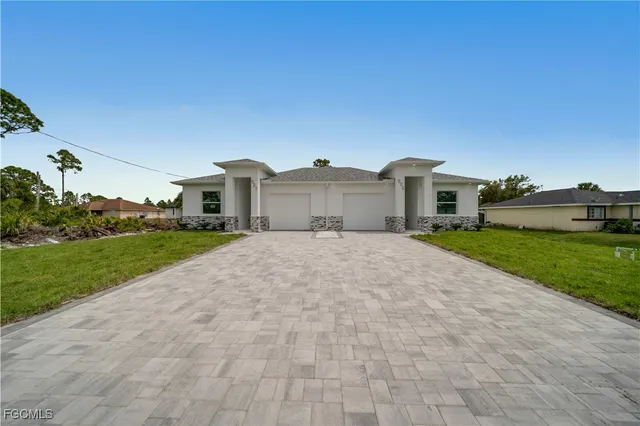 a view of a house with a yard and pathway