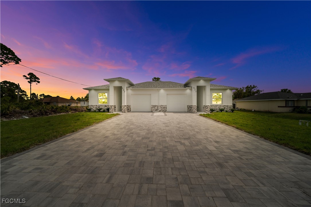 1153 Countess Avenue Lehigh Acres, FL 33974 - Photo 13 of 37 a front view of a house with a yard and garage