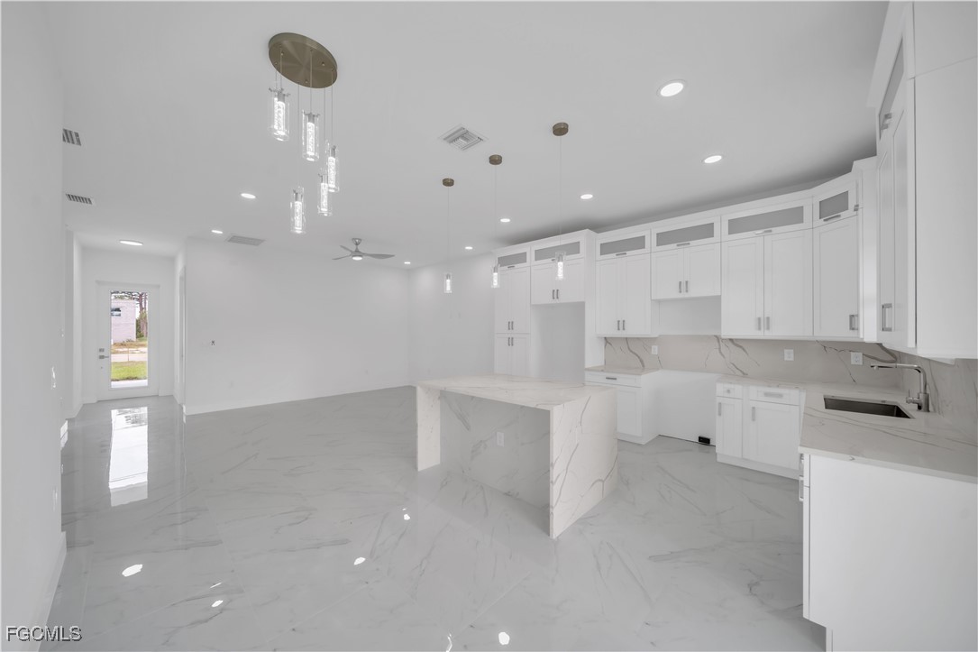 1153 Countess Avenue Lehigh Acres, FL 33974 - Photo 24 of 37 a large kitchen with white cabinets