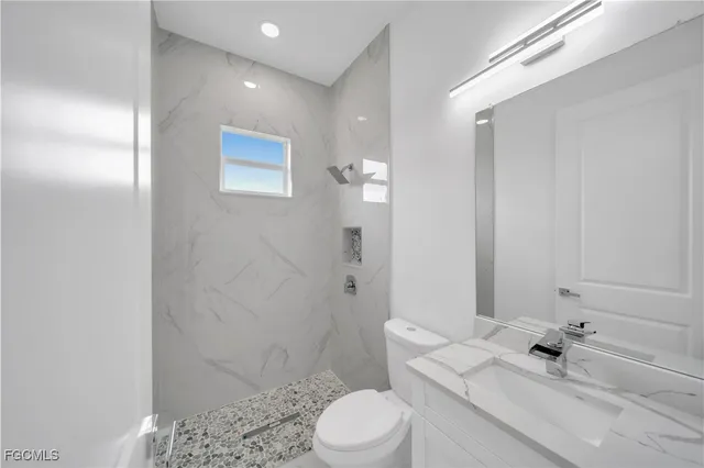 a bathroom with a sink a toilet and shower