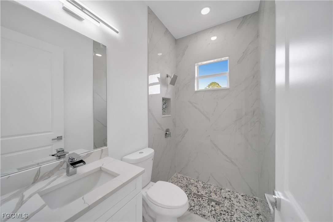 1153 Countess Avenue Lehigh Acres, FL 33974 - Photo 32 of 37 a bathroom with a sink a toilet and shower