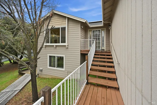 a view of a house with wooden deck front
