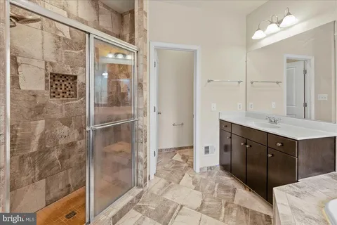 a bathroom with a shower sink and mirror