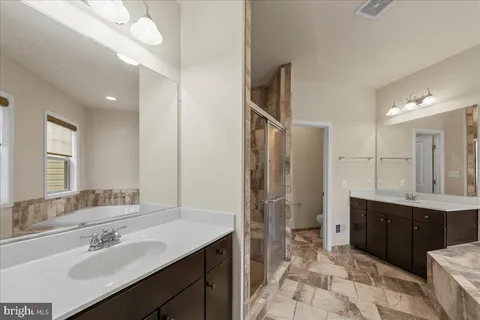 a spacious bathroom with a sink double vanity and a mirror
