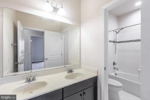 a bathroom with a toilet a sink a bathtub and a mirror
