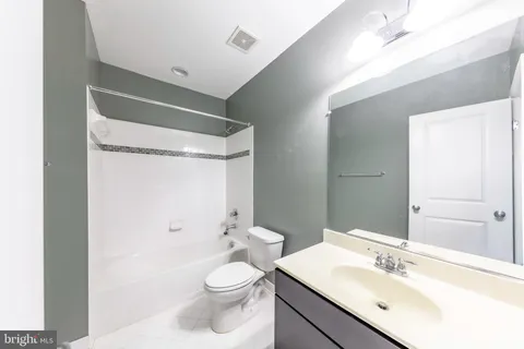a bathroom with a sink toilet vanity and shower