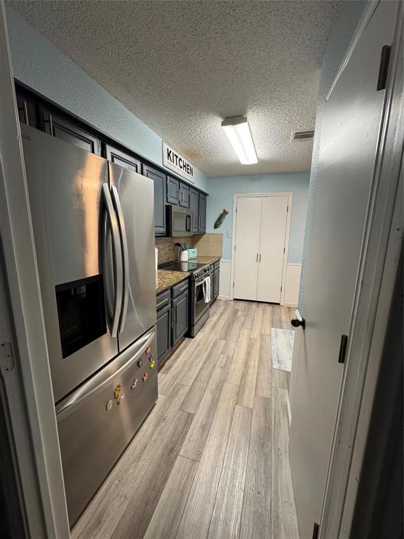 2412 Ridgestone Drive Dallas, TX 75287 - Photo 17 of 23 a view of a refrigerator in kitchen and wooden floor