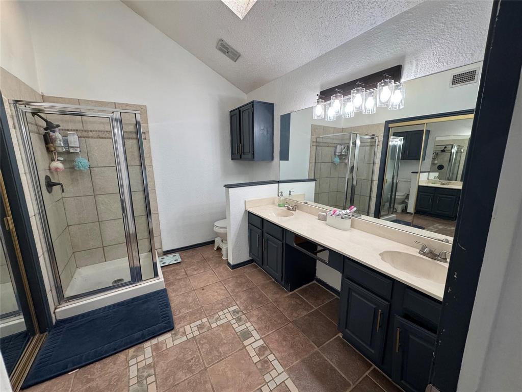 2412 Ridgestone Drive Dallas, TX 75287 - Photo 20 of 23 a bathroom with a double vanity sink a mirror and shower