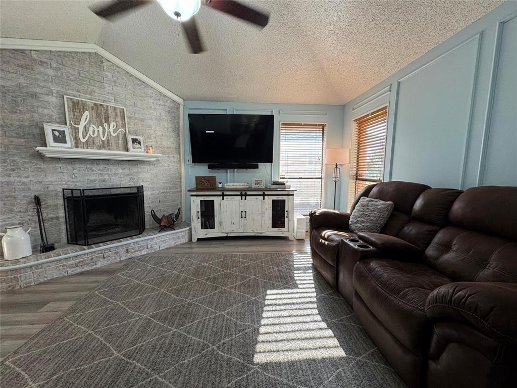 2412 Ridgestone Drive Dallas, TX 75287 - Photo 4 of 23 a living room with furniture a flat screen tv and a fireplace