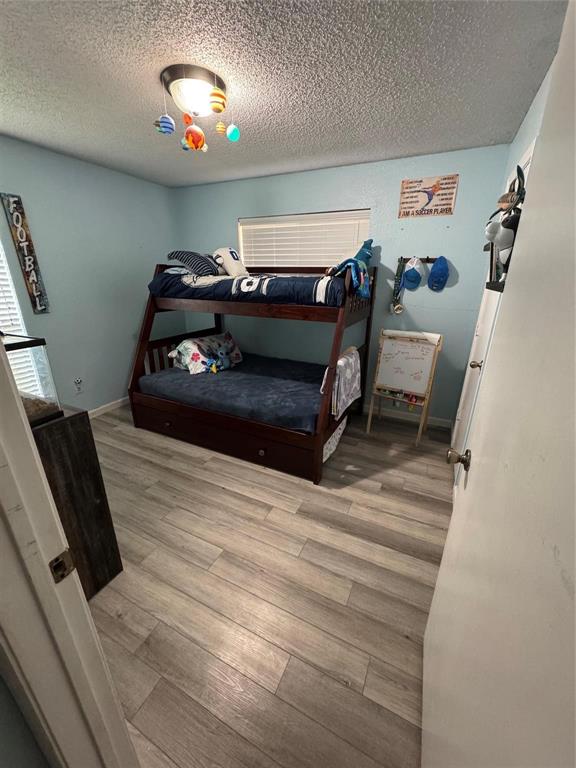 2412 Ridgestone Drive Dallas, TX 75287 - Photo 9 of 23 a bedroom with a bed and a chandelier