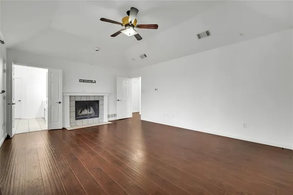 a view of an empty room with a fireplace and a window