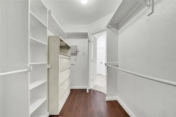 a view of walk in closet with wooden floor