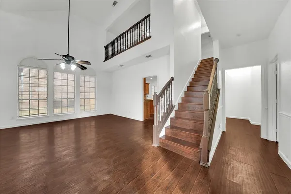 a view of a livingroom with wooden floor and stairs
