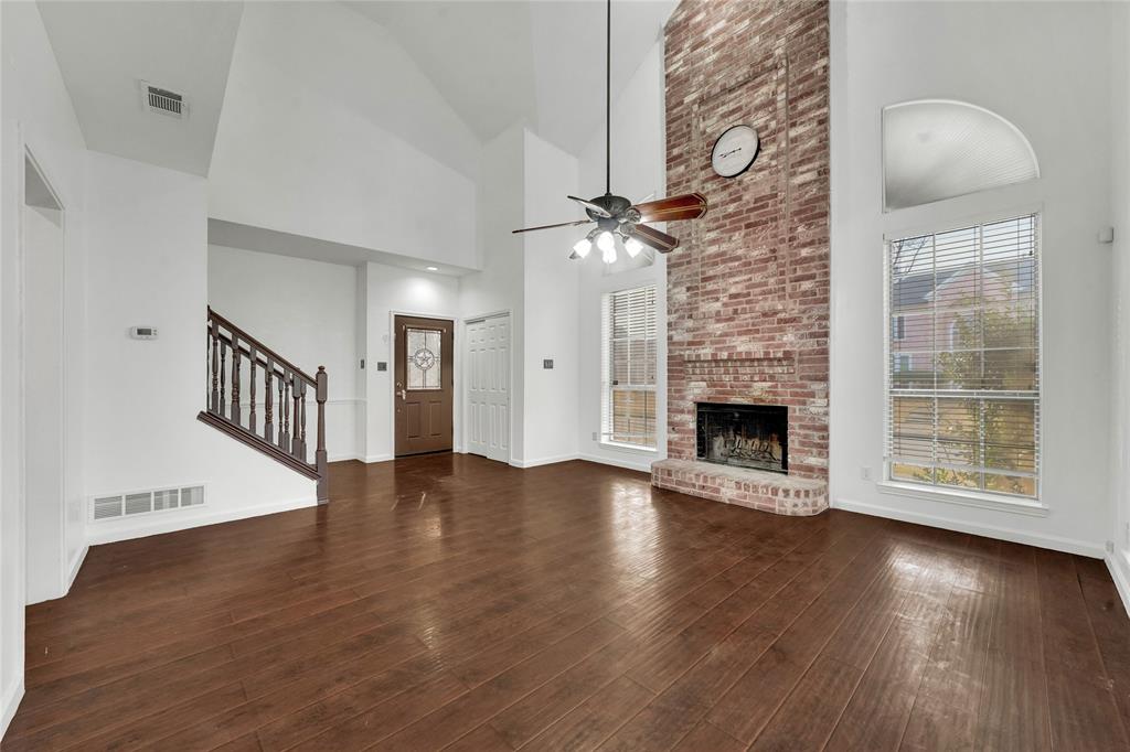 8105 Eagle Drive Rowlett, TX 75088 - Photo 7 of 35 an empty room with wooden floor fireplace and windows