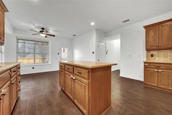 a kitchen with stainless steel appliances granite countertop a sink a stove a refrigerator cabinets and wooden floor