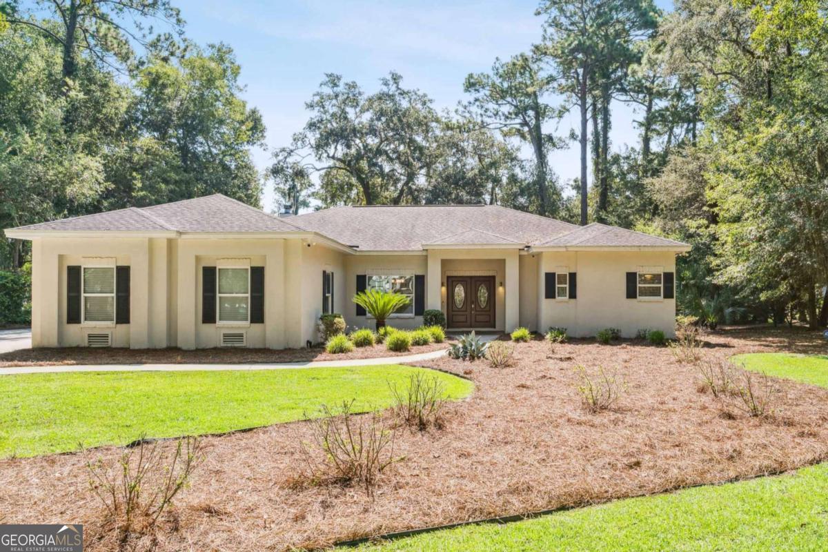 150 Rice Mill St. Simons Island, GA 31522 - Photo 1 of 38 a front view of a house with a yard table and chairs