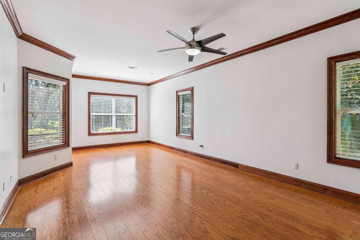 150 Rice Mill St. Simons Island, GA 31522 - Photo 13 of 38 a view of an empty room with a window and wooden floor