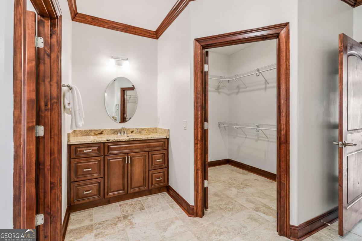 150 Rice Mill St. Simons Island, GA 31522 - Photo 16 of 38 a bathroom with a granite countertop sink a mirror and a vanity