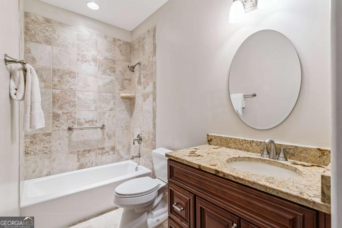 150 Rice Mill St. Simons Island, GA 31522 - Photo 19 of 38 a bathroom with a granite countertop sink a toilet and shower