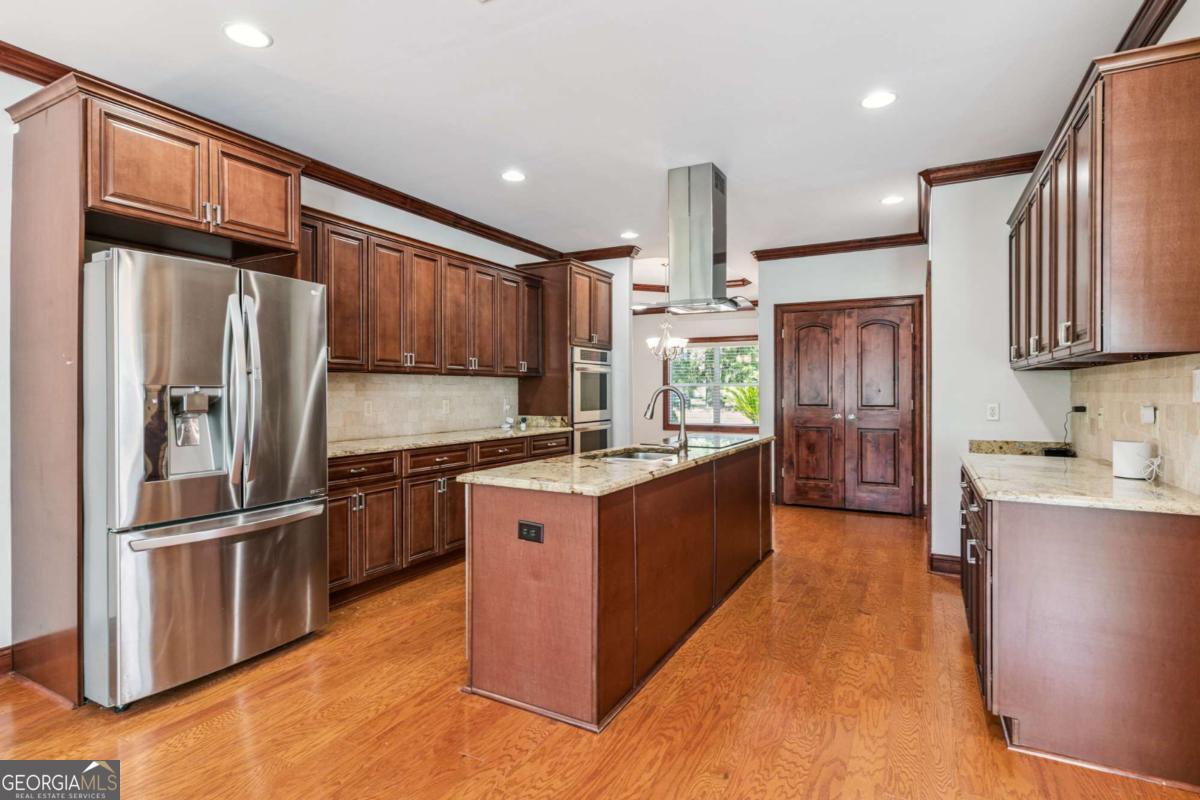 150 Rice Mill St. Simons Island, GA 31522 - Photo 8 of 38 a kitchen with stainless steel appliances granite countertop a refrigerator a sink dishwasher a stove and a oven with wooden floor
