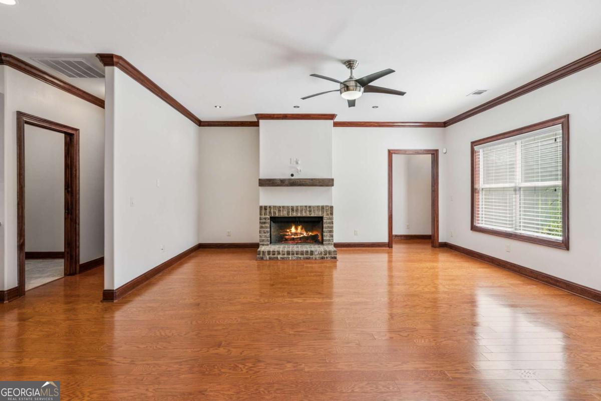 150 Rice Mill St. Simons Island, GA 31522 - Photo 10 of 38 a view of an empty room with wooden floor fireplace and a window