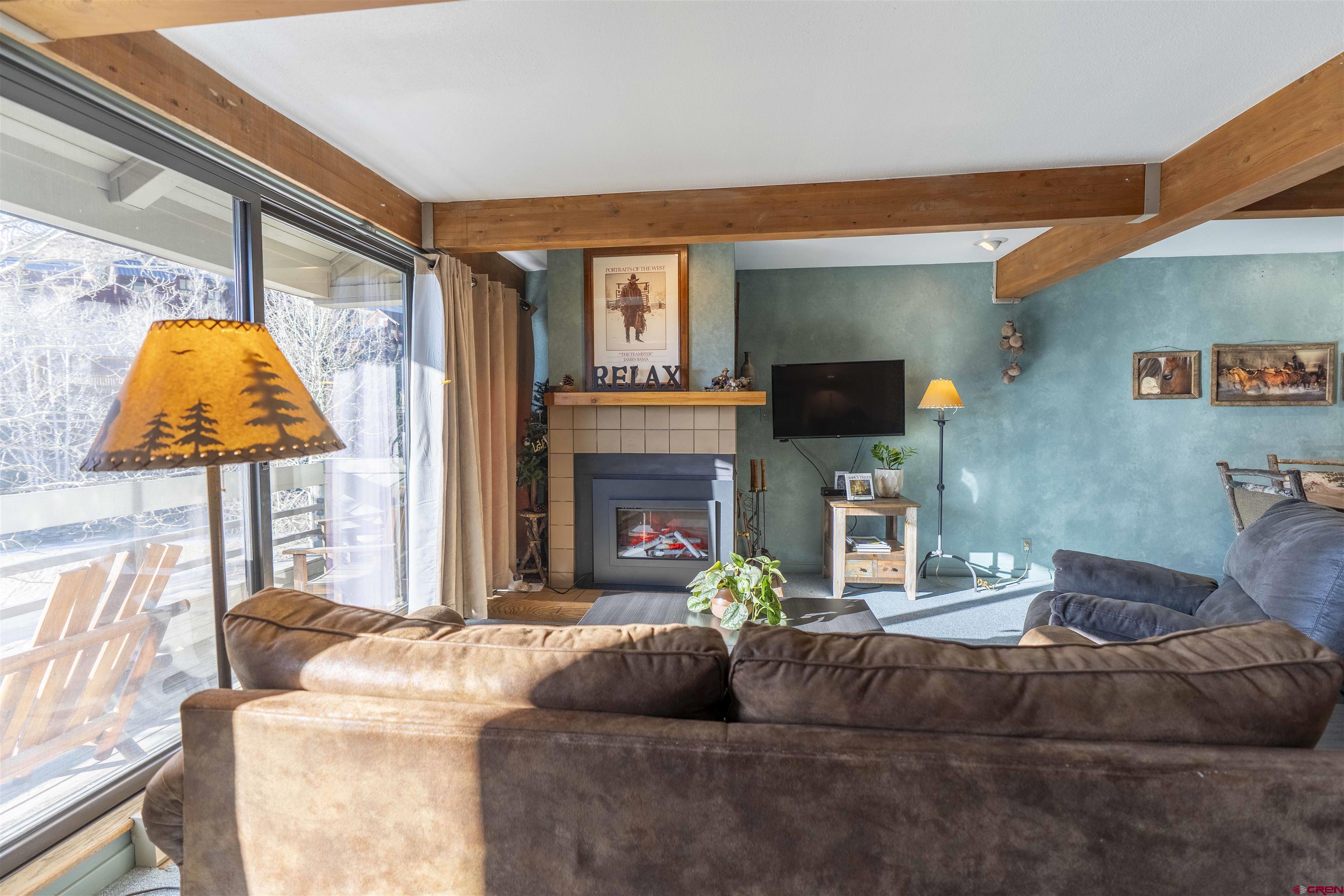 11 Hunter Hill Road, Unit 406 Crested Butte, CO 81225 - Photo 16 of 45 a living room with fireplace furniture and a flat screen tv