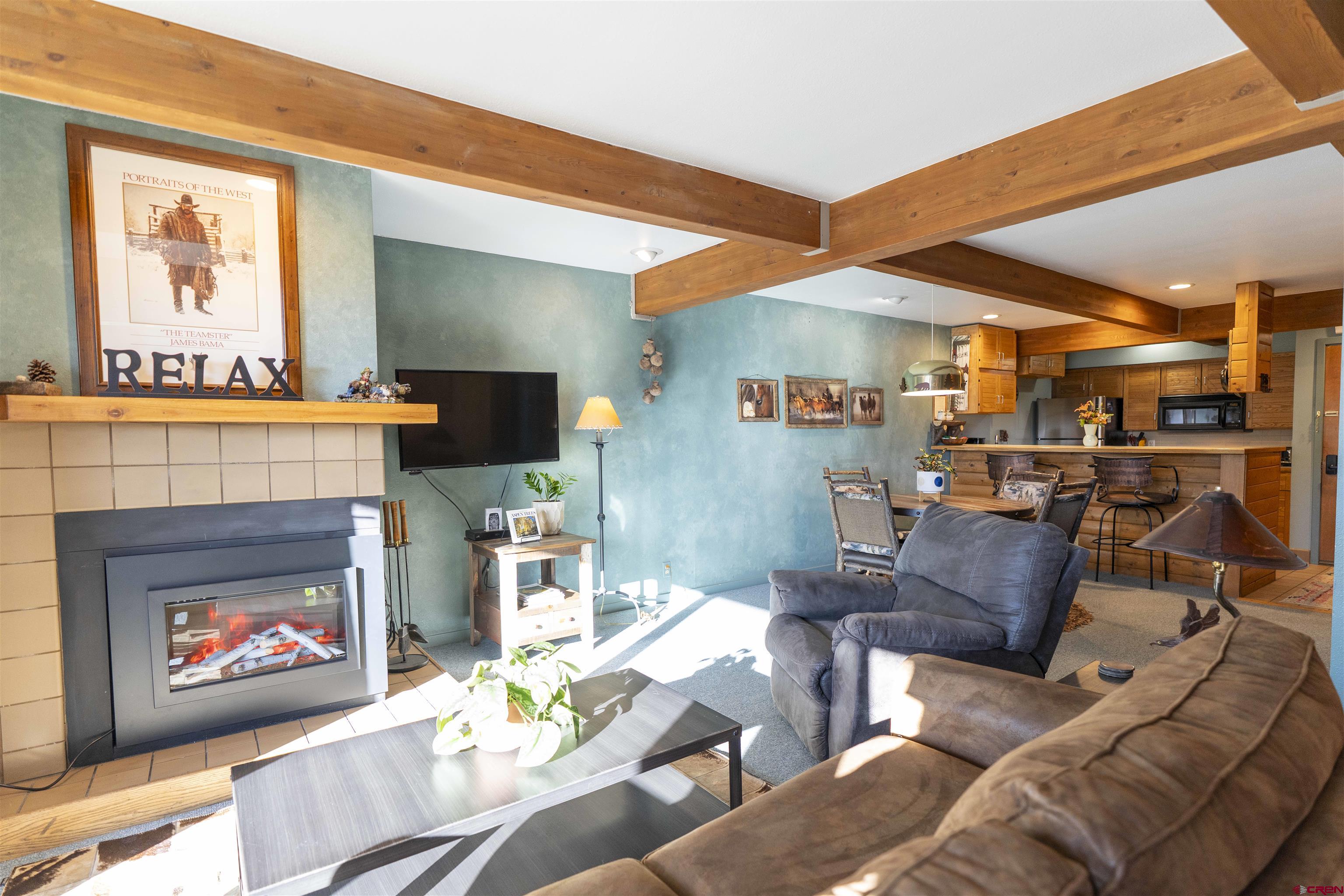 11 Hunter Hill Road, Unit 406 Crested Butte, CO 81225 - Photo 17 of 45 a living room with furniture a flat screen tv and a fireplace