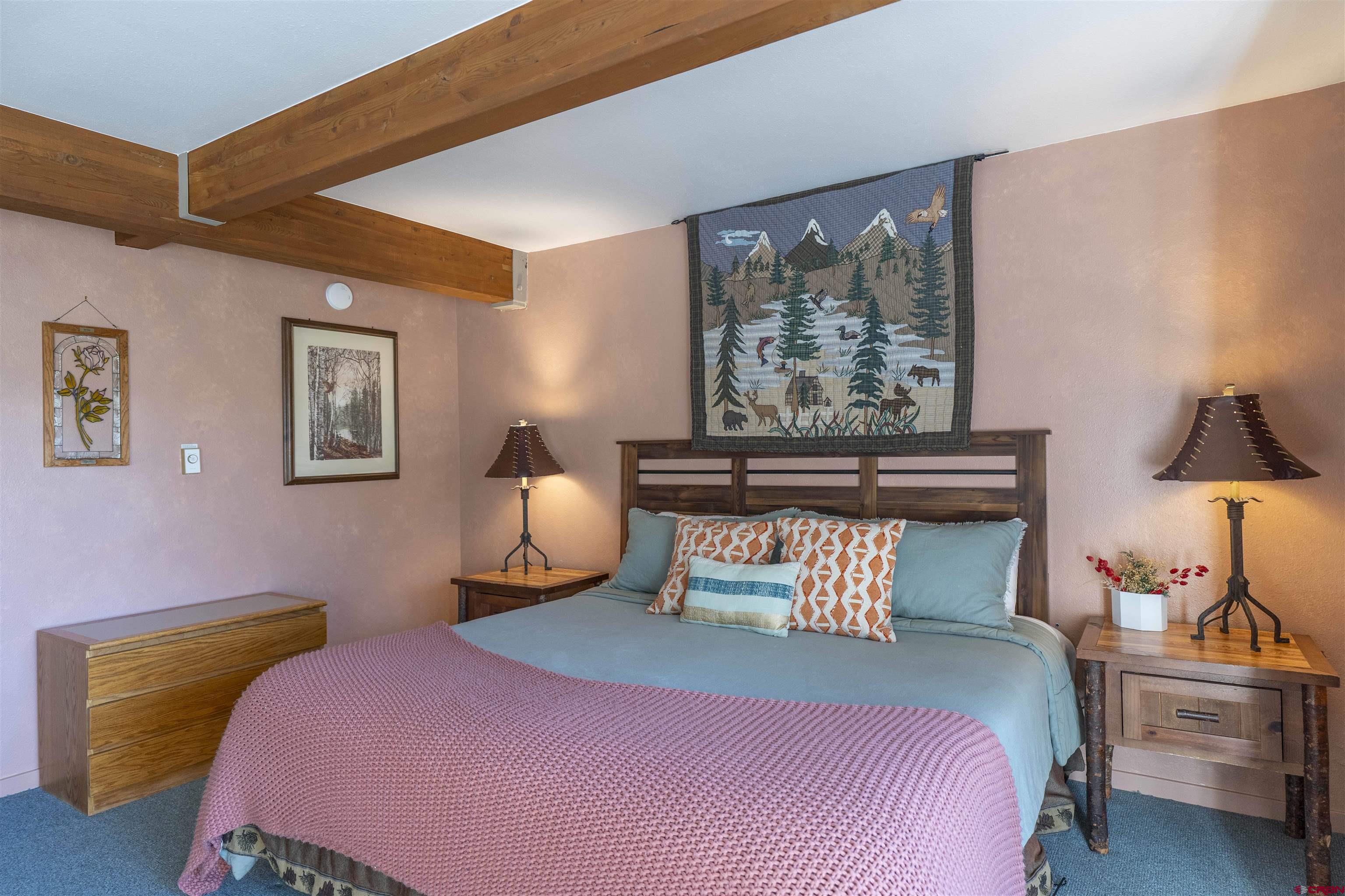 11 Hunter Hill Road, Unit 406 Crested Butte, CO 81225 - Photo 27 of 45 a bedroom with a bed and wooden floor