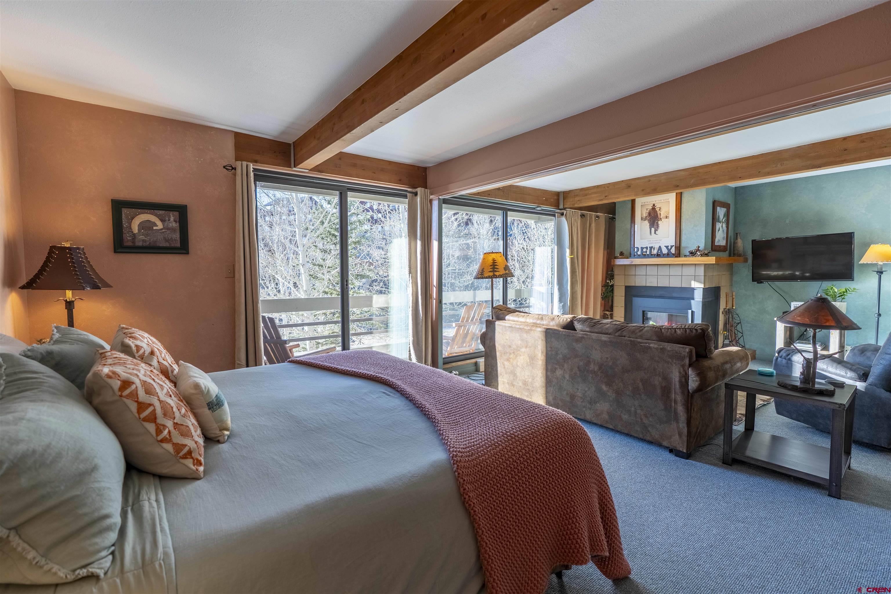 11 Hunter Hill Road, Unit 406 Crested Butte, CO 81225 - Photo 28 of 45 a bedroom with a balcony a bed and a couch