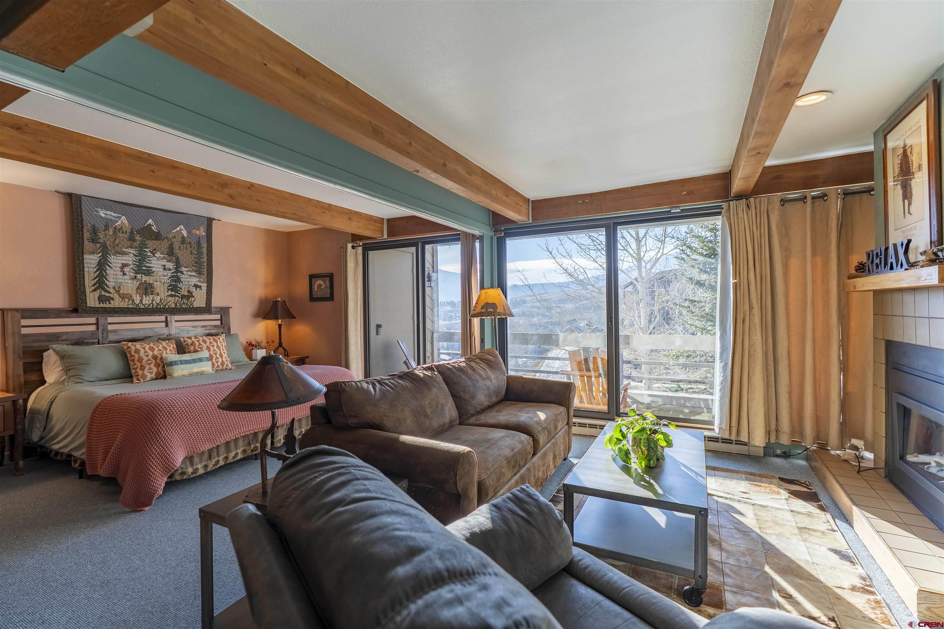 11 Hunter Hill Road, Unit 406 Crested Butte, CO 81225 - Photo 29 of 45 a bedroom with furniture and a large window