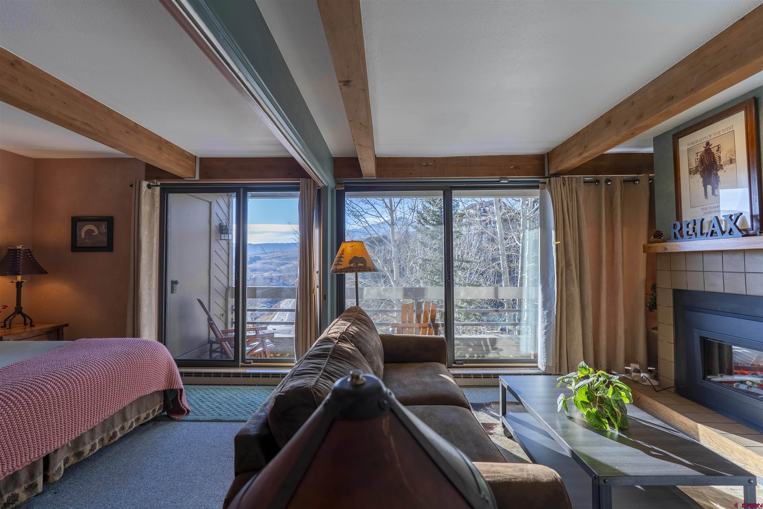 11 Hunter Hill Road, Unit 406 Crested Butte, CO 81225 - Photo 30 of 45 a living room with furniture a fireplace and a large window